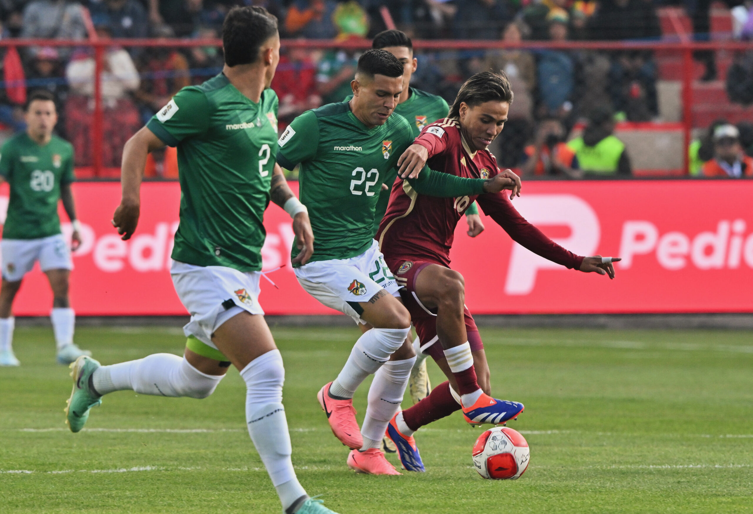 663D5C38 6D5A 430C A39F 4AEFC7805619 scaled En un emocionante encuentro disputado en el Estadio Municipal de El Alto, Bolivia sorprendió a todos al vencer a Venezuela con un contundente 4-0. Este partido, correspondiente a la séptima jornada de las Eliminatorias Sudamericanas para el Mundial de 2026, mostró a una selección boliviana dominante desde el inicio.El primer gol llegó temprano, a los 13 minutos, cuando Ramiro Vaca anotó con un potente disparo desde fuera del área, dejando sin opciones al arquero venezolano Rafael Romo. La presión boliviana continuó y, justo antes del descanso, Carmelo Algarañaz convirtió un penal para poner el 2-0 en el marcador.La segunda mitad comenzó con la misma intensidad. Apenas reiniciado el juego, Miguel Terceros aprovechó un centro raso de Roberto Fernández para marcar el tercer gol de Bolivia. La defensa venezolana no pudo contener los ataques bolivianos, y a los 70 minutos, Marcelo Martins selló la goleada con un cabezazo preciso tras un tiro de esquina.Con esta victoria, Bolivia suma tres puntos cruciales que le permiten salir del fondo de la tabla y soñar con la clasificación. Por su parte, Venezuela deberá replantear su estrategia si quiere mantenerse en la lucha por un cupo al Mundial.